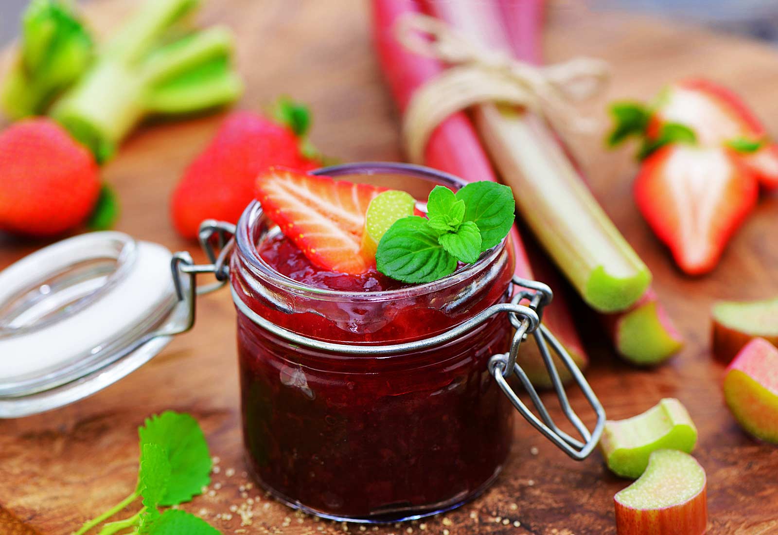 offenes Marmeladenglas mit Erdbeere als Dekoration